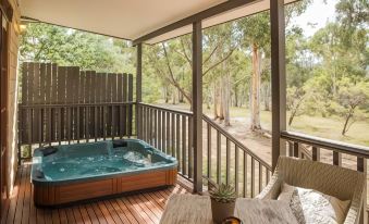 a hot tub on a wooden deck surrounded by trees , providing a serene and relaxing atmosphere at Maya Sanctuary