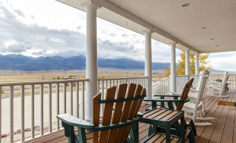a porch with two adirondack chairs placed on it , overlooking a beautiful view of mountains at Lamp Post Lodge