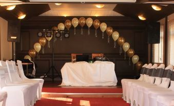 a white dining table set up for a special event , with balloons and confetti adorning the table at Birch Hotel