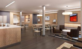 a modern hotel lobby with various seating options , including couches , chairs , and a dining table at Microtel Inn & Suites by Wyndham Sweetwater