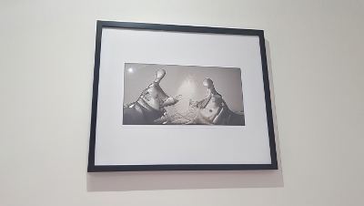 a black and white photograph of two horses shaking hands is framed and hanging on a wall at Vichy