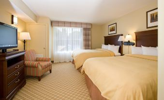 a hotel room with two beds , one on the left and one on the right side of the room at Country Inn & Suites by Radisson, Fredericksburg, VA