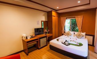 a hotel room with a bed , desk , and window , decorated with a heart - shaped arrangement of rose petals at Mammoth Resort