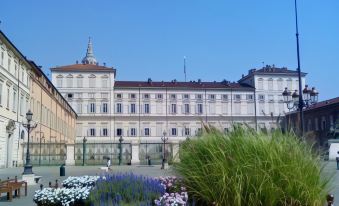 a large white building surrounded by a park , with a man standing in the middle of the scene at Hotel Diplomatic