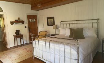 a white bedroom with a large bed , wooden ceiling , and a rug on the floor at Atlantic Hotel
