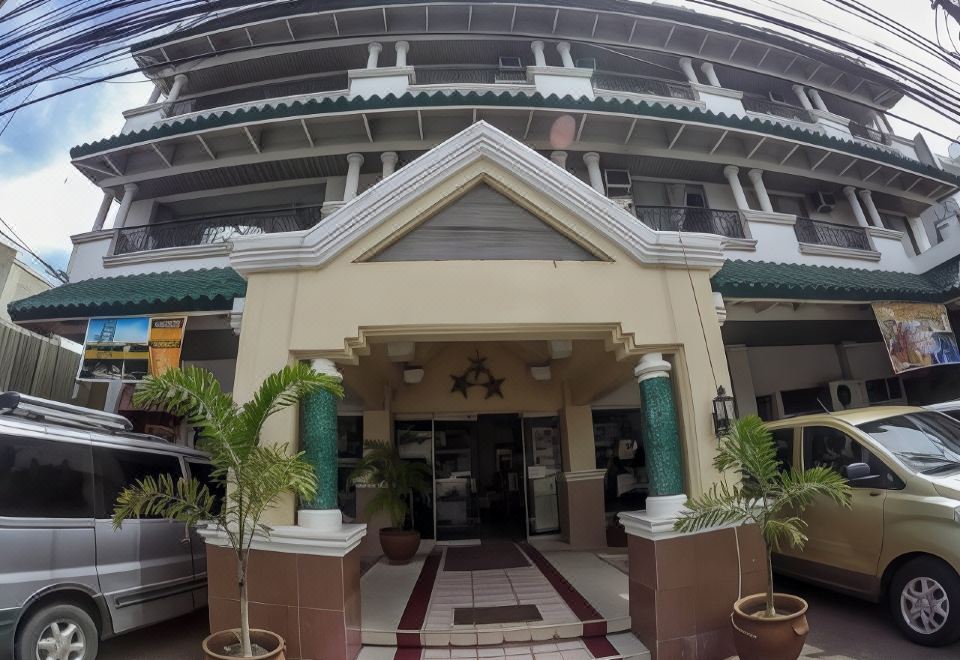 a hotel entrance with a red and white striped sign , surrounded by potted plants and a fence at Hotel Galleria