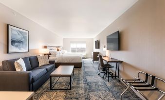 a modern hotel room with a large bed , couch , desk , and coffee table , along with other amenities at Four Points by Sheraton Elkhart