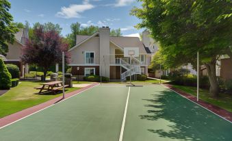 a tennis court is situated in front of a building with a staircase leading up to it at Residence Inn Hartford Windsor