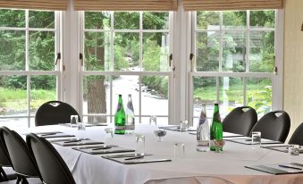 a dining table set for a formal meal , with several wine bottles placed on the table at Banchory Lodge Hotel