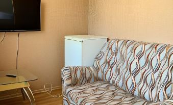 a living room with a couch , coffee table , and a television mounted on the wall at Gorodok