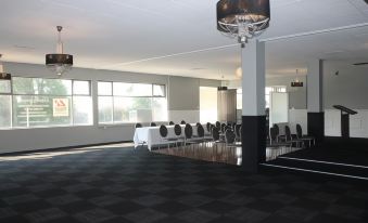 a large , empty room with black and white checkered flooring and a chandelier hanging from the ceiling at Hotel Launceston