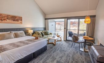 a modern hotel room with a large bed , couch , and sliding glass door leading to a balcony at Discovery Resorts - Kings Canyon