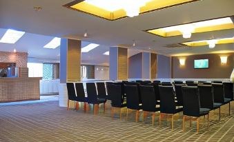 a conference room with rows of chairs arranged in a semicircle , ready for a meeting or presentation at The Park Hotel