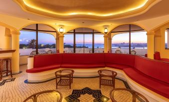 a large , red and white couch is in a room with a view of the ocean at Hotel Casabela