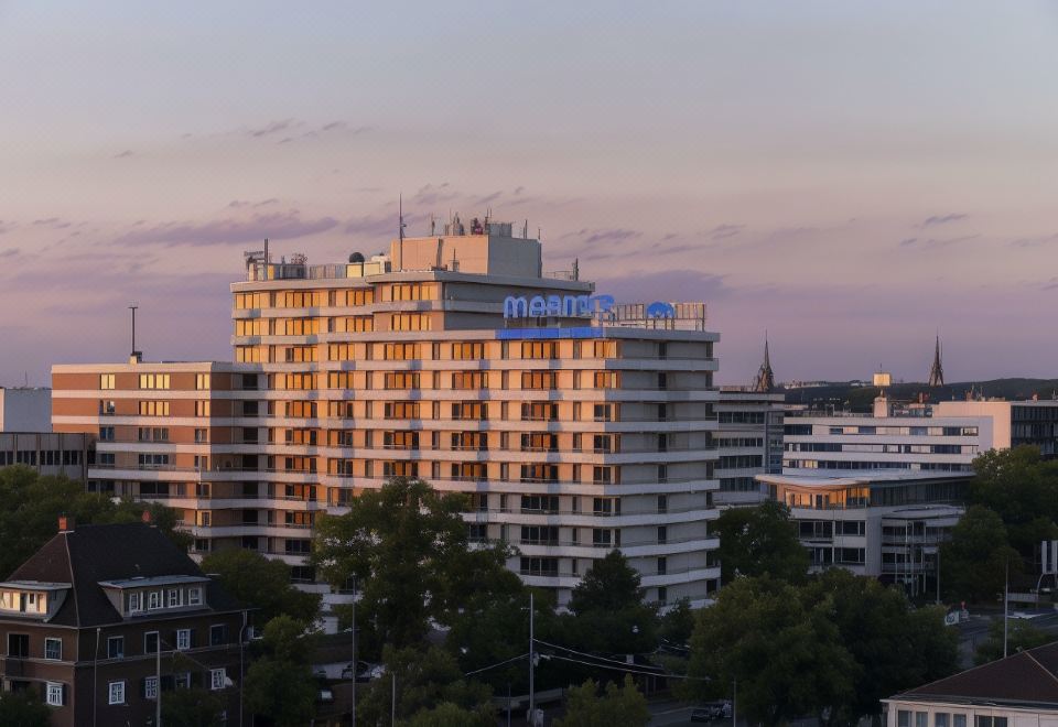 a city skyline at sunset , with the hilton hotel prominently visible in the background at Maritim Hotel Darmstadt