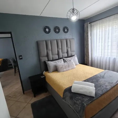 2 Bedroom apartment with 2 queen size beds & a cot, 10 minutes from JHB Airport.