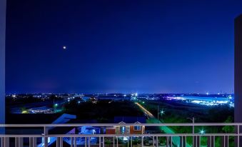 a night view of a city from a balcony with lights and buildings in the background at The Living Hotel SamutPrakan