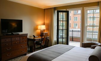 a hotel room with a bed , desk , and sliding glass door leading to a balcony at Royal Park Hotel