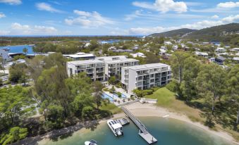 aerial view of a marina with multiple boats docked in the water , surrounded by buildings and trees at Sun Lagoon Resort