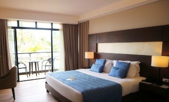 a large bed with blue pillows and a blue blanket is in a room with a sliding glass door at San Antonio Resort