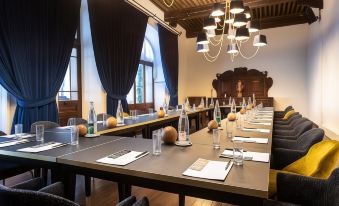 a conference room with a long table , chairs , and bottles of water set up for a meeting at Abbaye de Talloires