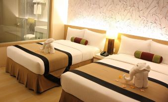 a hotel room with two beds , each adorned with white towels and a pair of elephant - shaped pillows at Mount Sea Resort Hotel and Restaurant Cavite