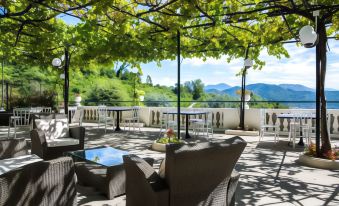 a patio area with a table and chairs under a pergola , overlooking a beautiful mountain view at Hotel Scapolatiello