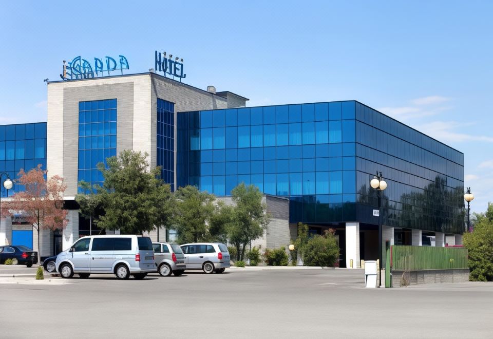 "a large blue building with the word "" bardo "" on top is surrounded by cars and trees" at Garda Hotel