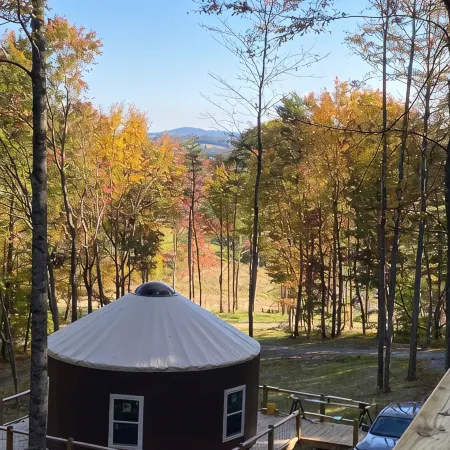 Elevated eclectic yurt with wrap-around porch, hot tub, and mountain view!