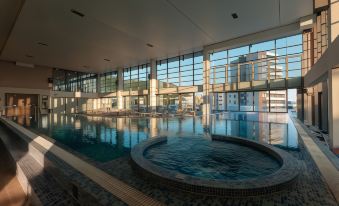 an indoor swimming pool with a large circular pool in the middle , surrounded by lounge chairs and umbrellas at Sunscape Puerto Plata All Inclusive