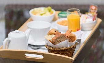 a wooden tray filled with a variety of food items , including bread , oranges , and other breakfast items at Best Western Astoria