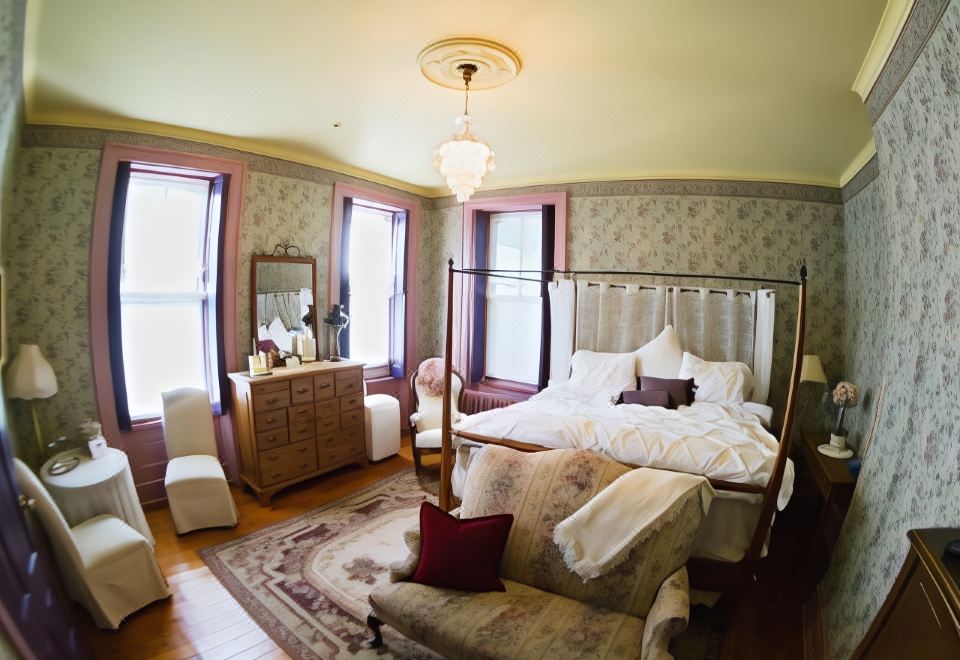 a spacious bedroom with a large bed , a couch , and a rug on the floor at Susquehanna Manor Inn