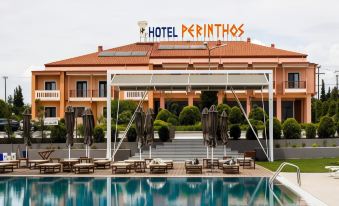 a large hotel with a swimming pool and umbrellas is shown in front of a building at Perinthos Hotel