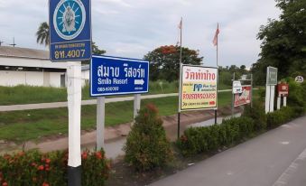 a signboard with various signs and directions in both english and thai , indicating the location of various locations at Smile Resort