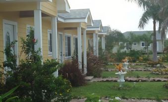 a row of houses with white trim and a red roof are surrounded by greenery at Country Cove