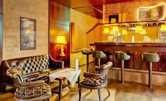 a cozy living room with wooden furniture , including a couch , chairs , and a dining table at Hotel National