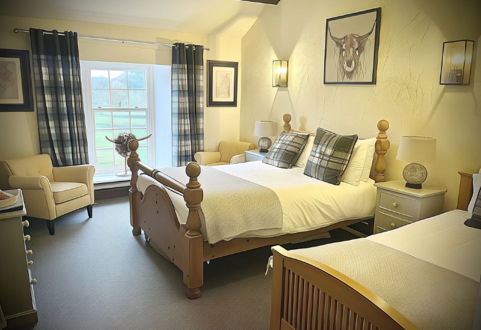 a large bed with a wooden headboard and footboard is in a room with two chairs and framed pictures on the wall at The Brown Horse Inn