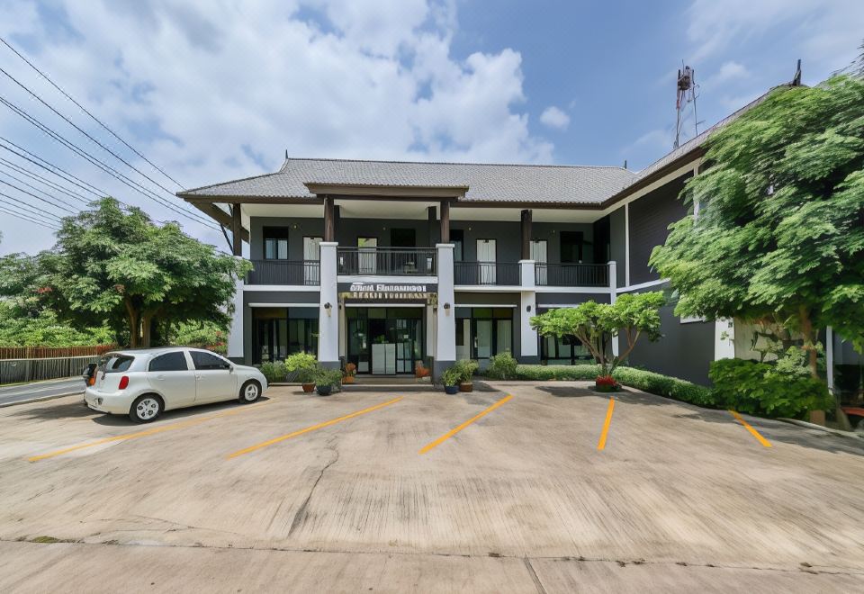 a modern building with a gray exterior and white car parked in front of it at Baan Kieng Tawan