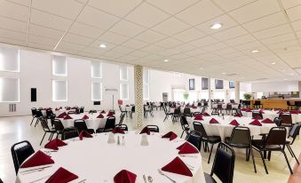 a large dining room with round tables and chairs arranged for a group of people at Ramada by Wyndham Richland Center