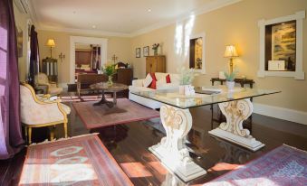 a large living room with a glass coffee table in the center , surrounded by multiple chairs and couches at Jacobs Creek Retreat