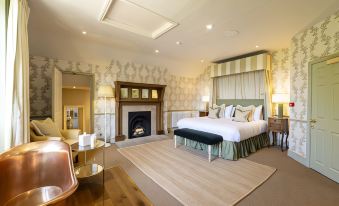 a spacious bedroom with a large bed and a fireplace , creating a cozy and inviting atmosphere at The Barnsdale, Rutland