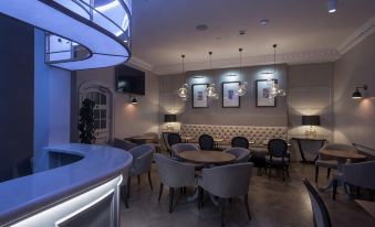 a dining area with a round dining table surrounded by chairs and a couch in the background at The Kings Head Hotel