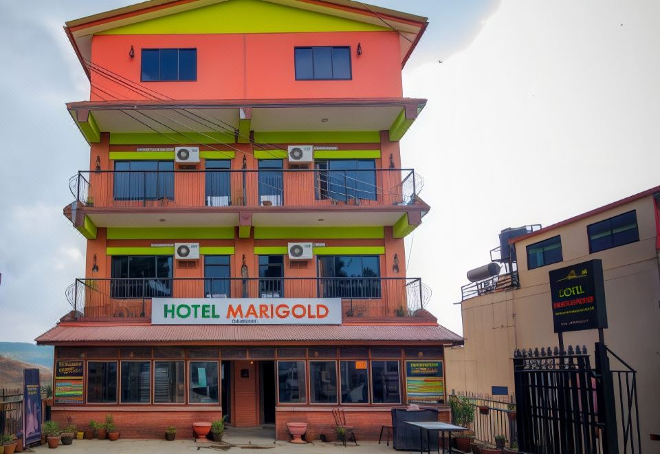 "a three - story building with a sign that says "" hotel marigold "" is surrounded by plants and fences" at Hotel Marigold