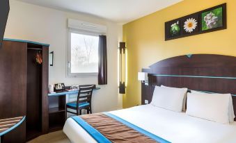 a hotel room with a large bed , a desk , and a window overlooking the city at Sure Hotel by Best Western St-Amand-Les-Eaux