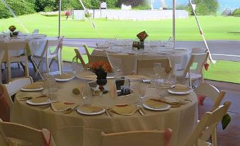 a well - arranged banquet table set up for a wedding reception , with multiple chairs arranged around it at Agaming Golf Resort