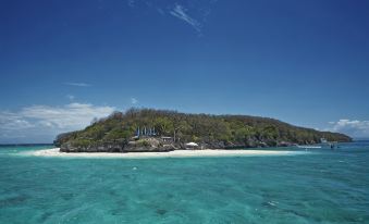 a large body of water , possibly an ocean or a lake , with a small island in the distance at Bluewater Sumilon Island Resort