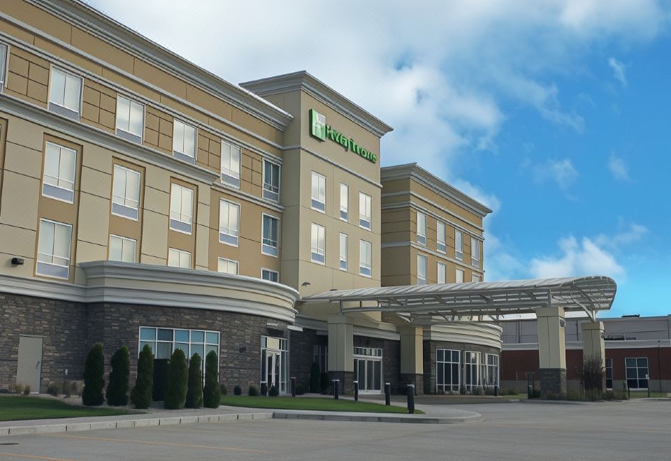 "a large hotel building with a green sign that says "" holiday inn express "" in front of it" at Holiday Inn & Suites Hopkinsville - Convention Ctr