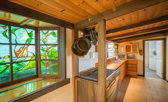 a kitchen with wooden ceiling , blue glass panels , and large windows that offer views of the outdoors at Bruny Island Escapes and Hotel Bruny