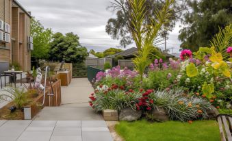 a beautiful garden with a variety of flowers and plants , creating a serene and inviting atmosphere at Parkwood Motel & Apartments