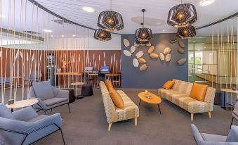 a modern lobby with various seating options , including couches and chairs , as well as decorative wall hangings at Bunbury Hotel Koombana Bay